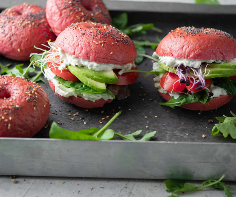 Bagels rosa com pasta de frango, abacate e folhas verdes