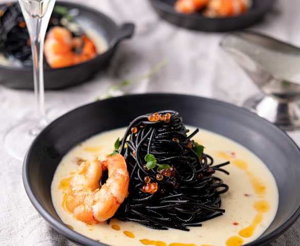 Schwarze Spaghetti mit Parmesan-Sauce und Garnelen