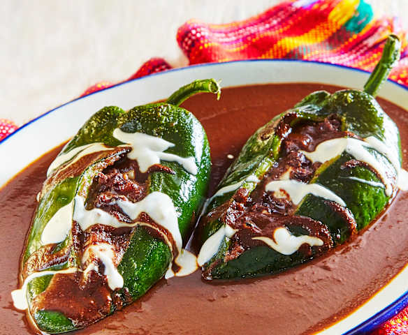 Chiles rellenos de frijol con mole negro