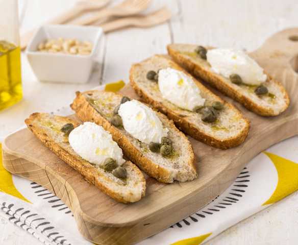 Crostini di pane integrale con crema al caprino, capperi e pinoli Crostini di pane integrale con crema al caprino, capperi e pinoli