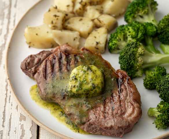 Bistecca di manzo con burro alle erbe, patate al rosmarino e broccoli Bistecca di manzo con burro alle erbe, patate al rosmarino e broccoli