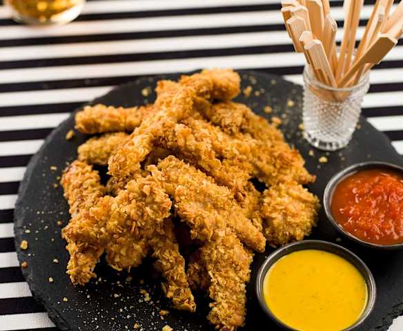 Tiras de frango panadas com molhos barbecue e de caril