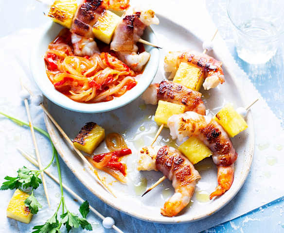 Brochetas de langostinos, beicon y piña con guarnición de verduras