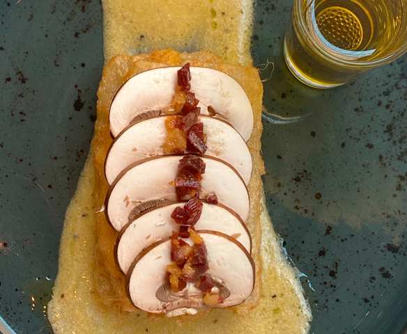 Penca de acelga rebozada rellena de bechamel, crema de aceite de oliva, hongo laminado y polvo de ibérico.