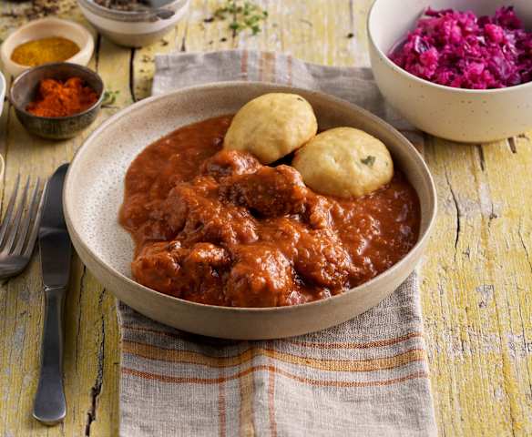 Gulash y buñuelos de pan con guarnición de lombarda