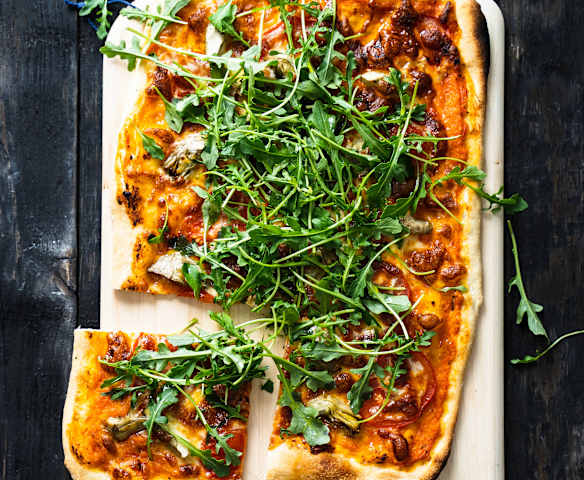 Pizza veggie aux tomates, artichauts, mozzarella et roquette