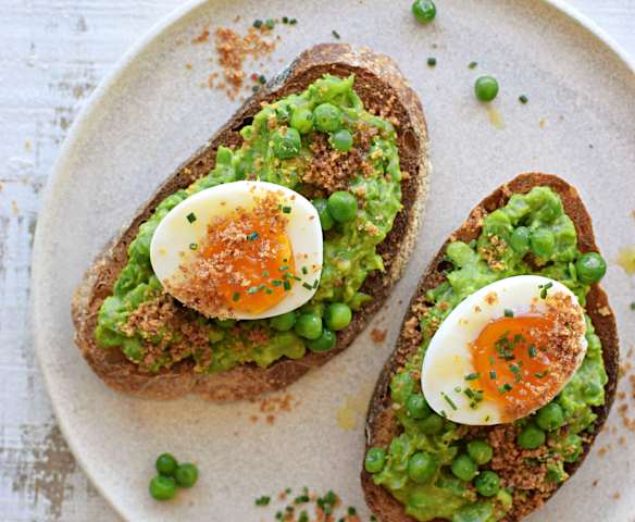 Tostadas con puré de arvejas, palta y polvo de tocino