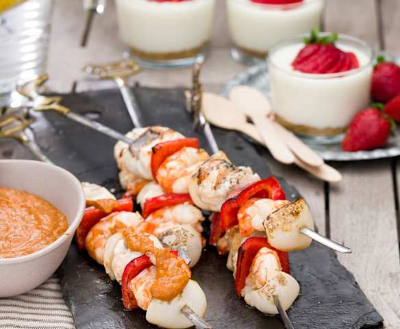 Brochetas de rape y langostinos con emulsión de escalivada. Vasitos de limón y fresas.