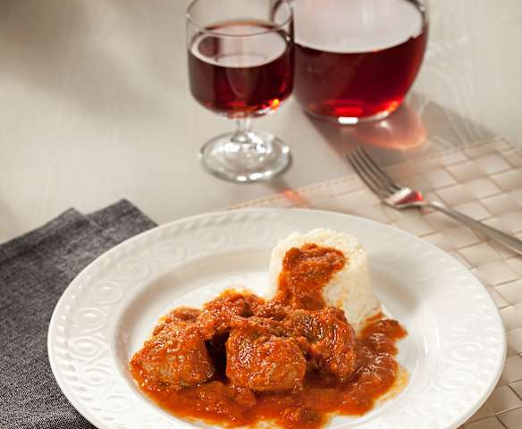 Carrilladas de cerdo con tomate y guarnición de arroz blanco