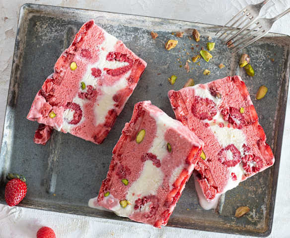 Parfait de fresa y nata con pistachos y frambuesas