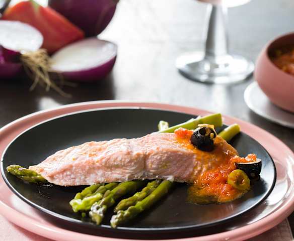 Salmón al vapor con salsa de tomate rosa y aceitunas y espárragos verdes