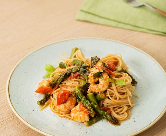 Espaguetis con espárragos, tomates y langostinos para dos