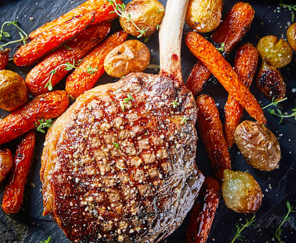 Tomahawk asado con espárragos a la bernesa