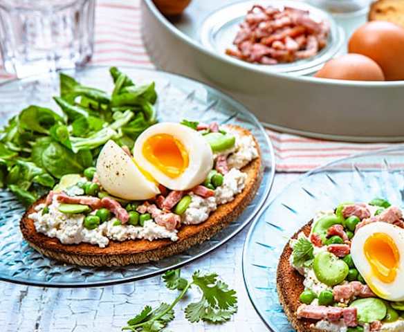 Tartine de chèvre frais, fèves, petits pois, lardons et œuf mollet