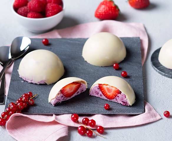 Cúpula crujiente de chocolate blanco con mousse de frutos rojos y corazón de fresa