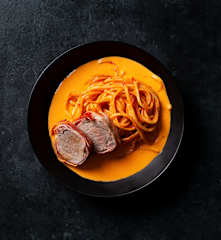 Solomillo de cerdo con beicon al horno y espaguetis en salsa de pimiento