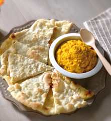 Triangoli di pane arabo con hummus di zucca
