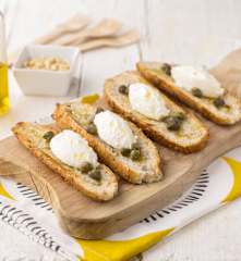 Crostini di pane integrale con crema al caprino, capperi e pinoli