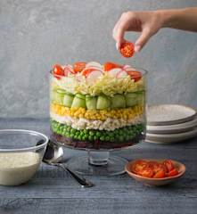 Layered vegetable salad with creamy herb dressing