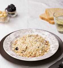 Risotto con speck, noci di macadamia e prugne secche