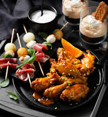 Menú: Brochetas de melón con jamón. Alitas de pollo picantes a la naranja. Postre de galleta caramelizada