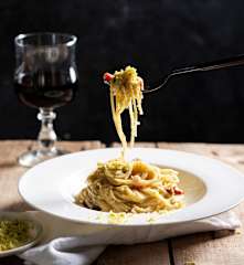 Espaguetis cremosos con queso y pistachos