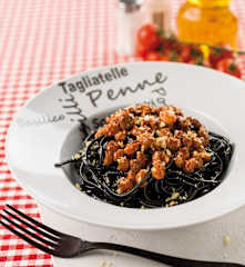 Esparguete preto com frutos secos, anchovas e molho de tomate