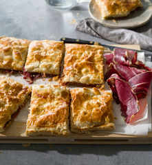 Empanada de hojaldre con pimientos confitados, cecina y queso de cabra