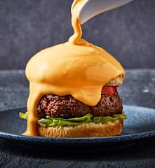 Hamburguesa bañada en salsa de queso