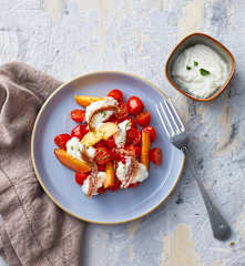 Insalata di pomodorini e pesche con crema di burrata e acciughe