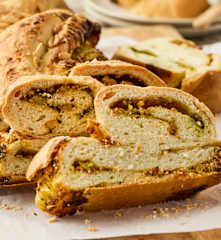 Pain tressé au levain, au pesto de basilic et garni de pistaches méditerranéennes