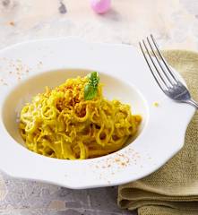 Nidi di tagliolini in salsa di carciofi e bottarga con riccioli di tuorli