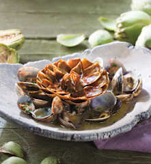 Flor de alcachofas confitadas con almejas en salsa verde