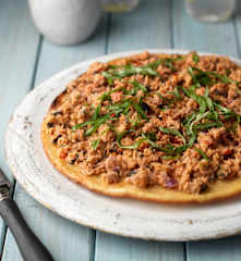 Socca con cobertura de atún, aceitunas y alcaparras