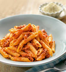 Penne mit Tomaten, Schinken und scharfer Salami