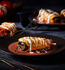 Chiles rellenos de chicharrón en salsa de frijol negro