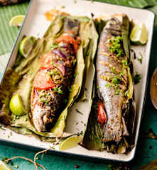 Poisson à la mode du Yucatán cuit dans des feuilles de bananier avec du riz au maïs