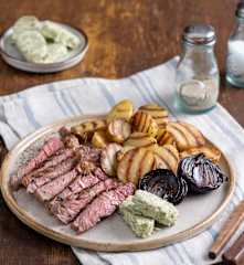 Grillowane steki wołowe z masłem cebulowo-ziołowym, młodymi ziemniakami i cebulą