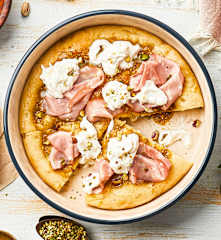 Pizza con pesto de pistachos, queso cremoso y mortadela