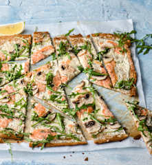 Flammekueche aux graines de lin avec saumon, champignons et salade de roquette